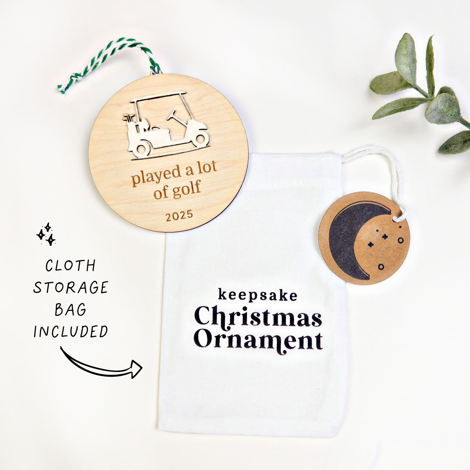 Wooden ornament with golf cart design and text, displayed with a cloth storage bag on a white background.