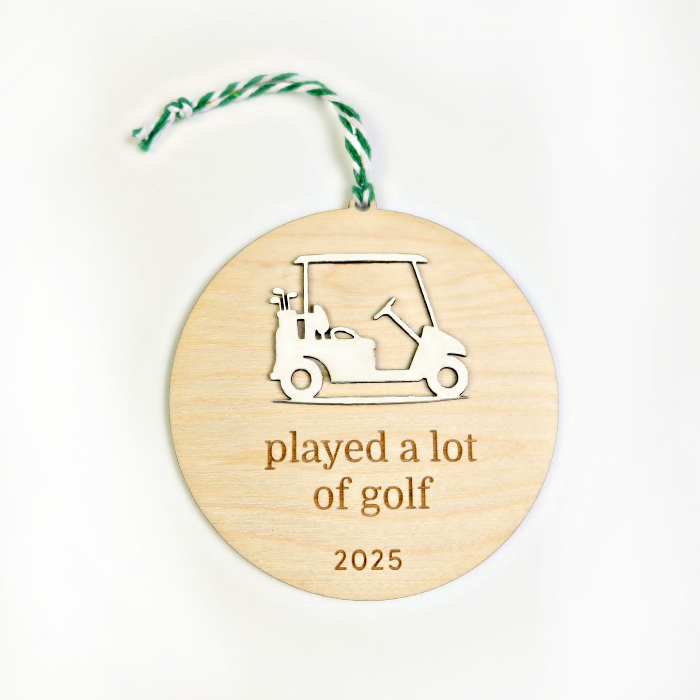 Wooden ornament with golf cart design and 'played a lot of golf 2025' text on a white background