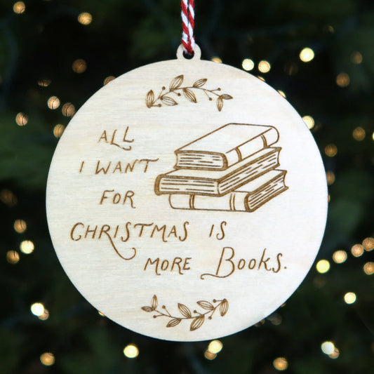 Decorative ornament with 'All I want for Christmas is more books' text on a Christmas tree.