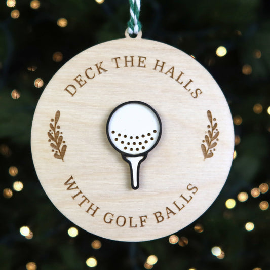 Wooden ornament with golf ball design and text 'Deck the halls with golf balls' on a Christmas tree background.