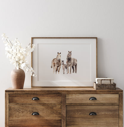 Framed artwork of horses on a wooden dresser with decorative items.