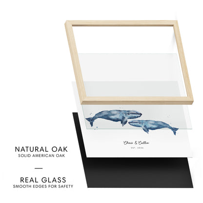Framed artwork with whales on a white background, featuring natural oak frame and real glass.