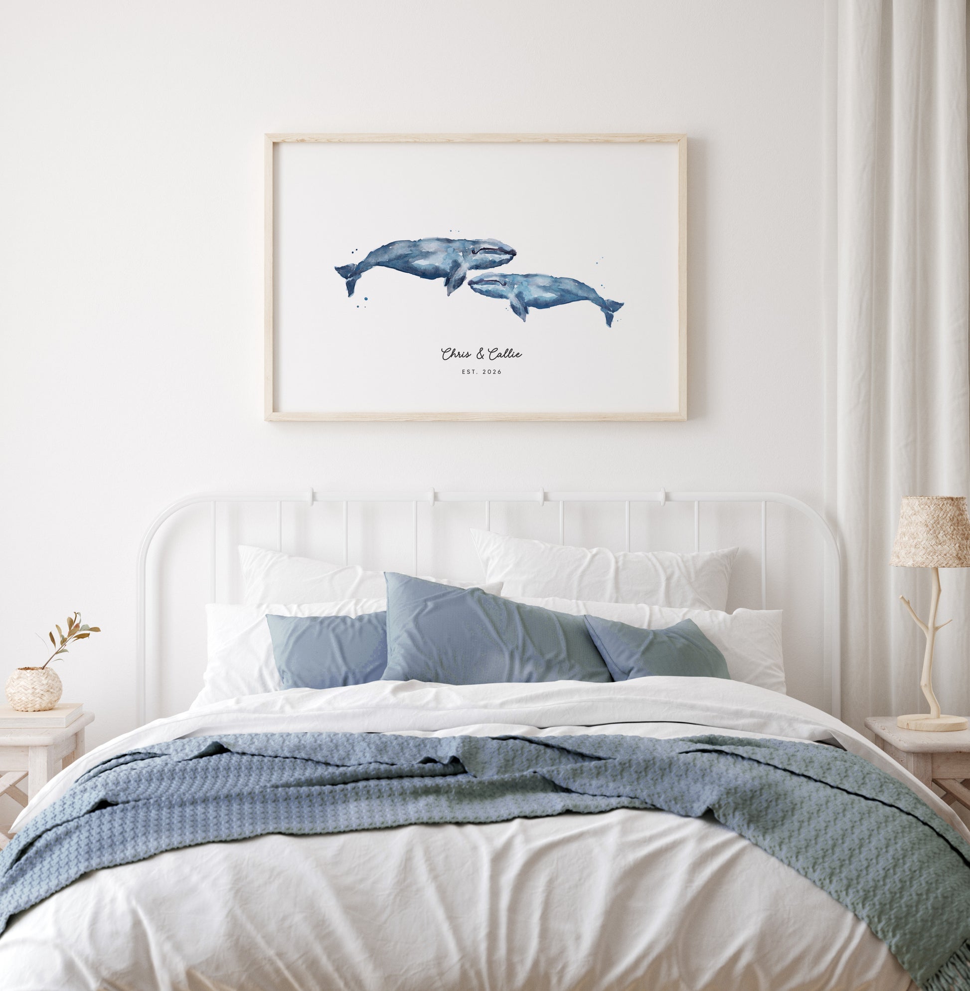 Bedroom with a framed artwork of two whales on the wall above a bed.
