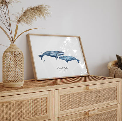 Framed artwork of two whales on a wooden cabinet with decorative elements.